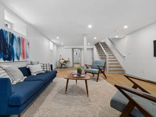 Finished basement living area with a staircase by KNT Construction